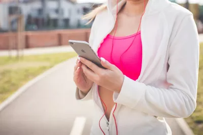 Najlepsze darmowe aplikacje bikini na ciało : Kobieta w białej kurtce, trzymając srebrny iPhone